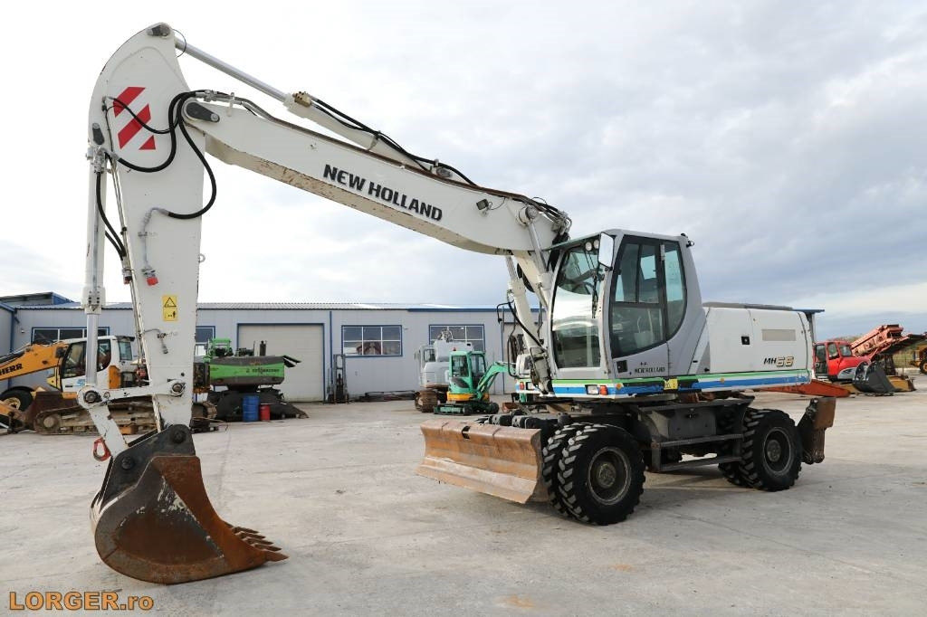 New Holland MH 6.6 + Sandvic Hammer - Ekskavator me goma: foto 1 New Holland MH 6.6 + Sandvic Hammer - Ekskavator me goma: foto 1