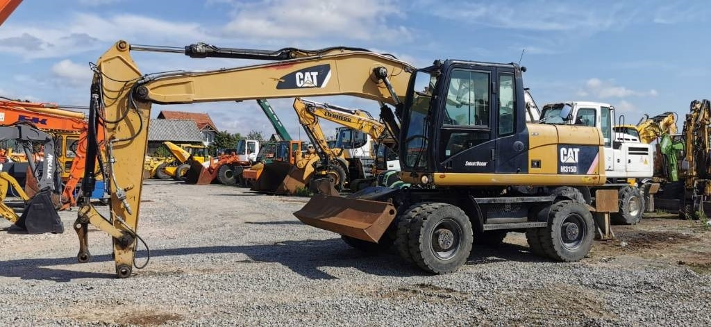 CAT M 315 D - Ekskavator me goma: foto 1 CAT M 315 D - Ekskavator me goma: foto 1